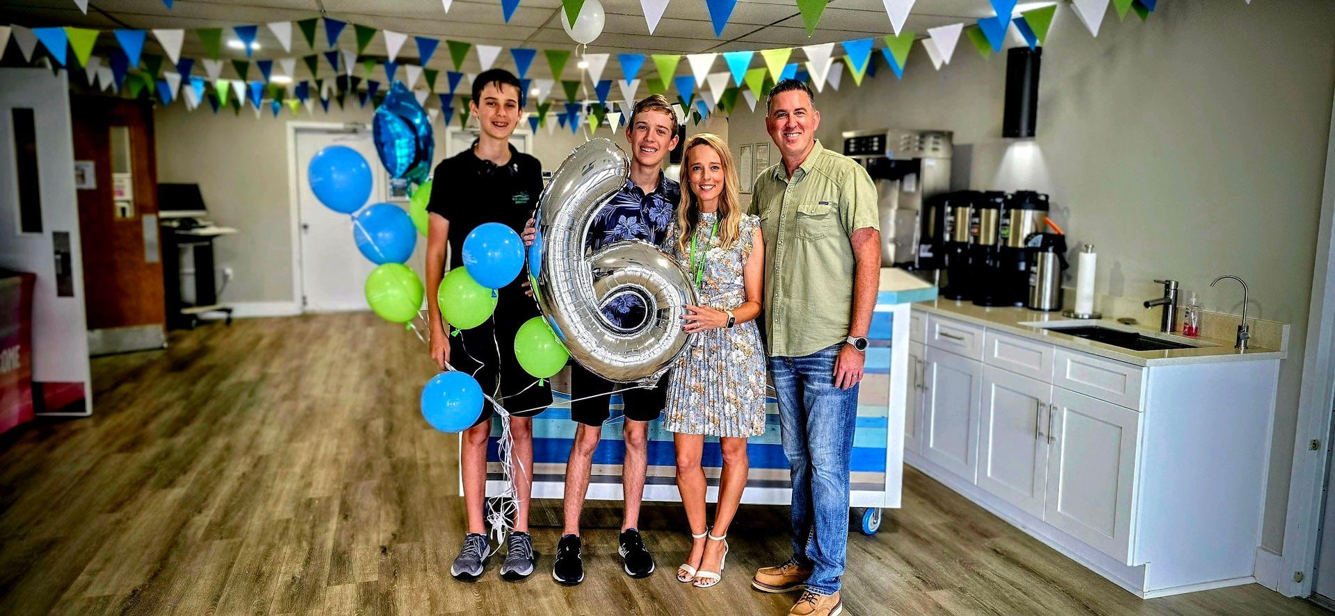 A man , woman , two boys and a girl are posing for a picture.
