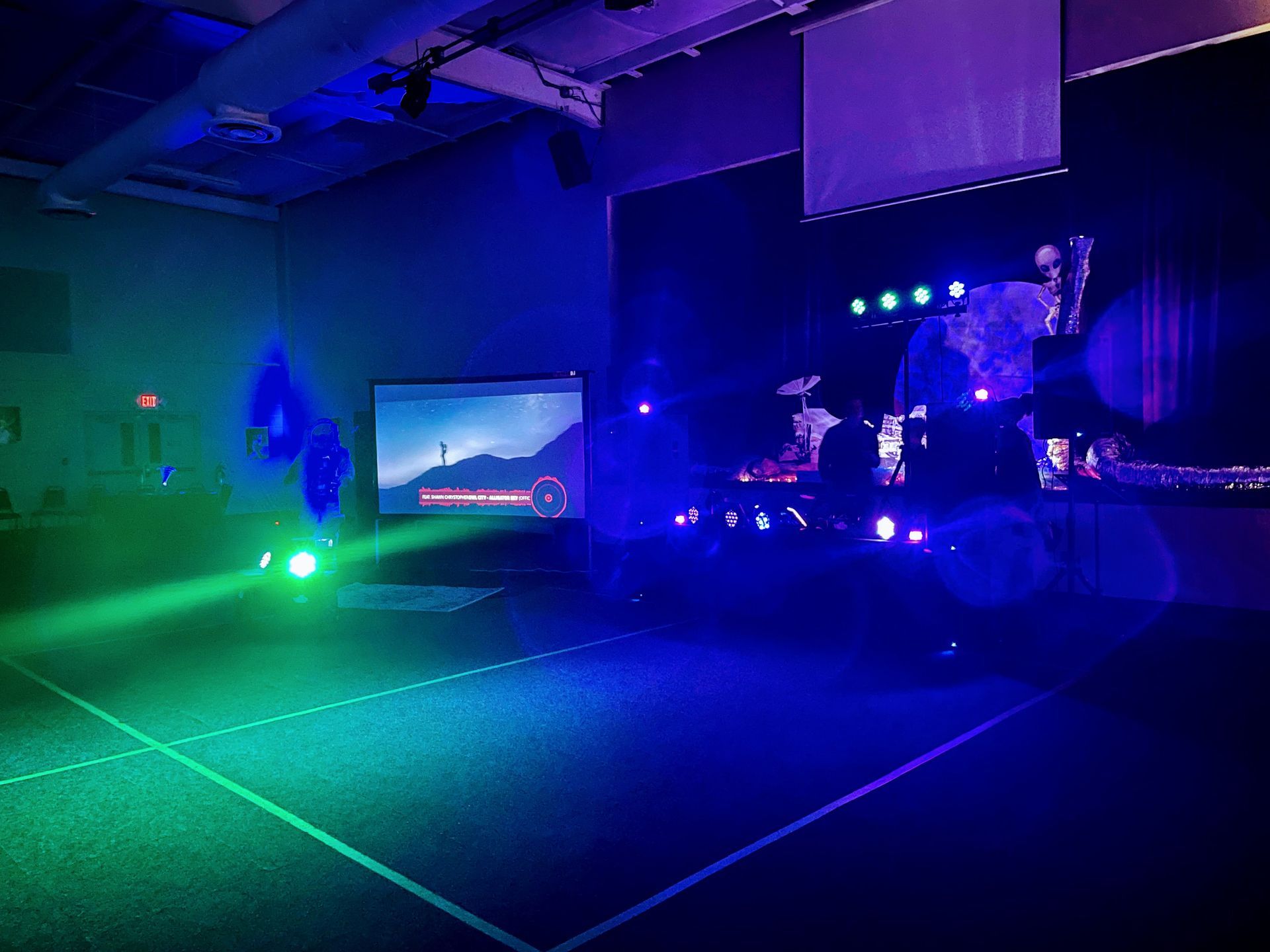 A basketball court is lit up with blue and green lights.