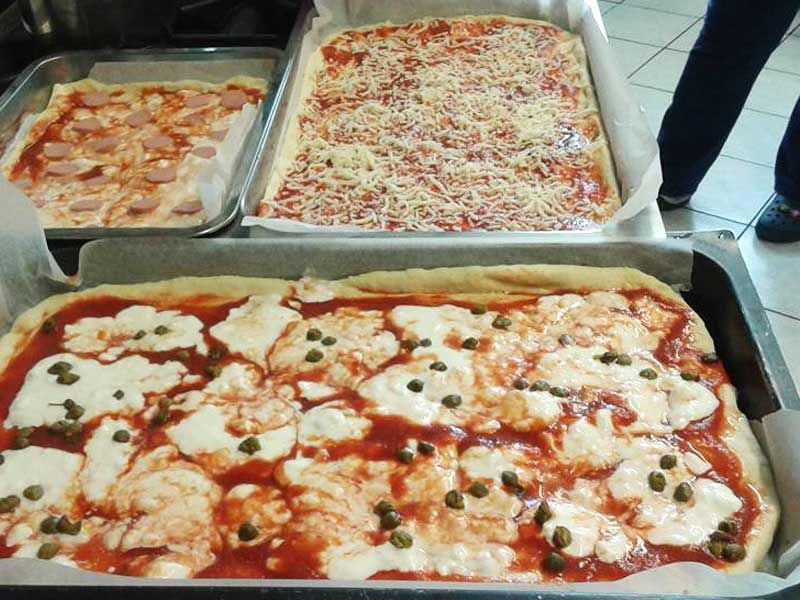 Pizze di vario tipo su teglie
