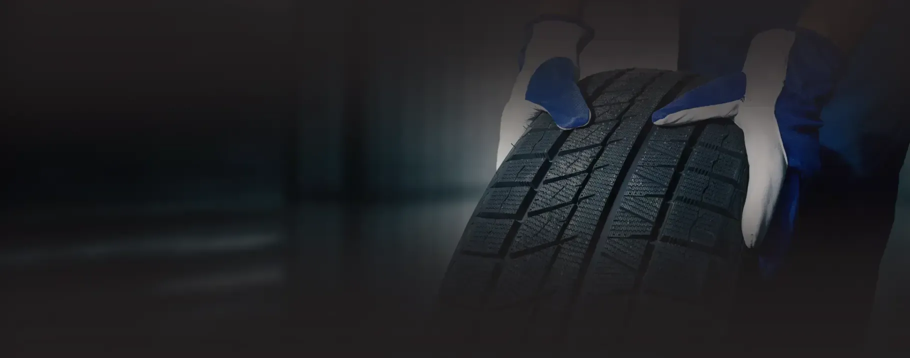 Up close to technician wearing gloves holding rim of tire | Power Tire
