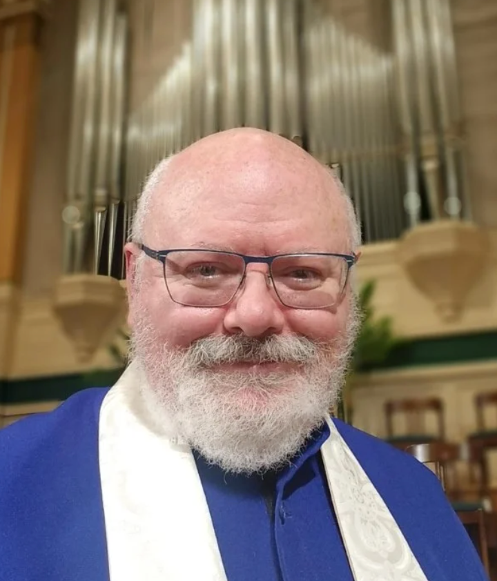 A head shot of John Walko, organist. John is standing in front of the organ