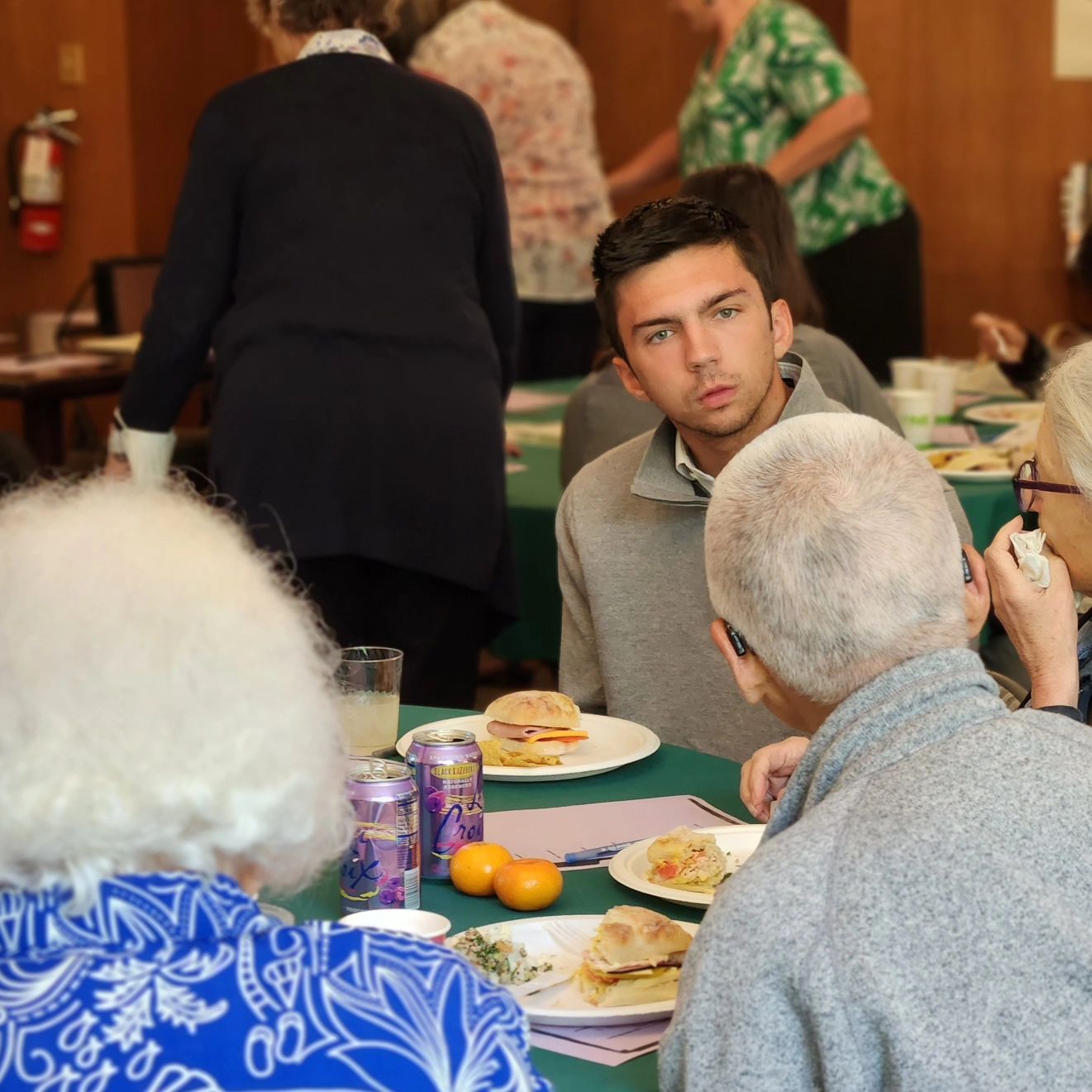 An inquisitive young man engages in conversation with the rest of the table at an anti-racism workshop held in the Lounge