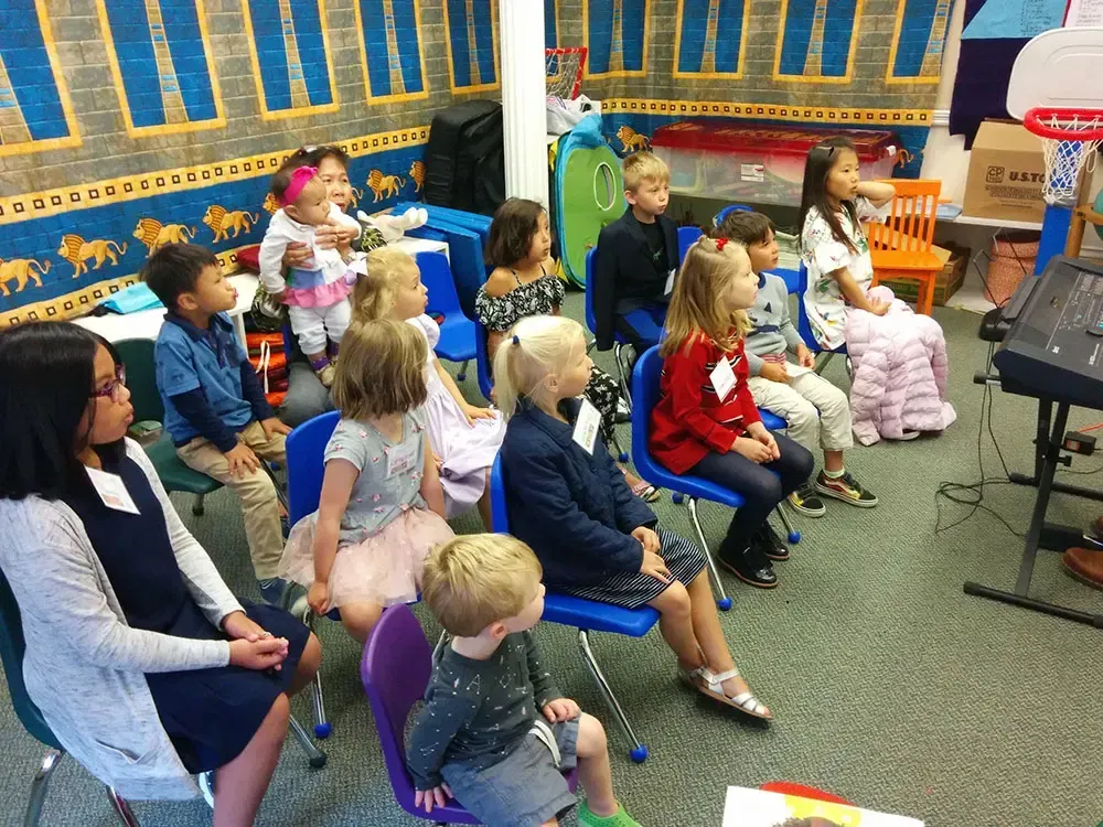 A group of children sitting in chairs in the lower-level of Calvary's building