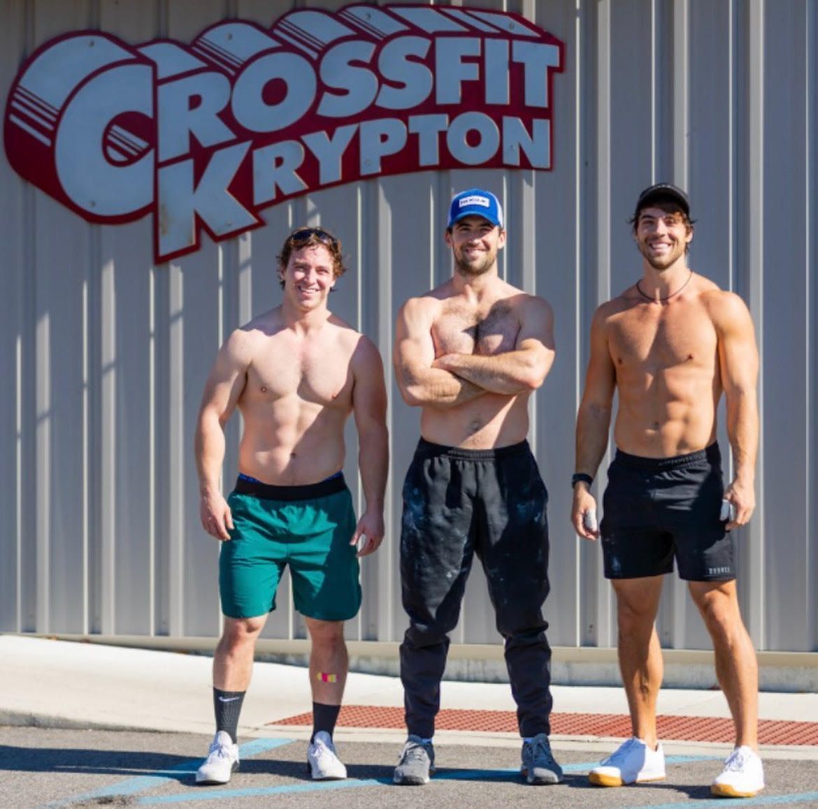 Three men standing in front of a crossfit krypton sign
