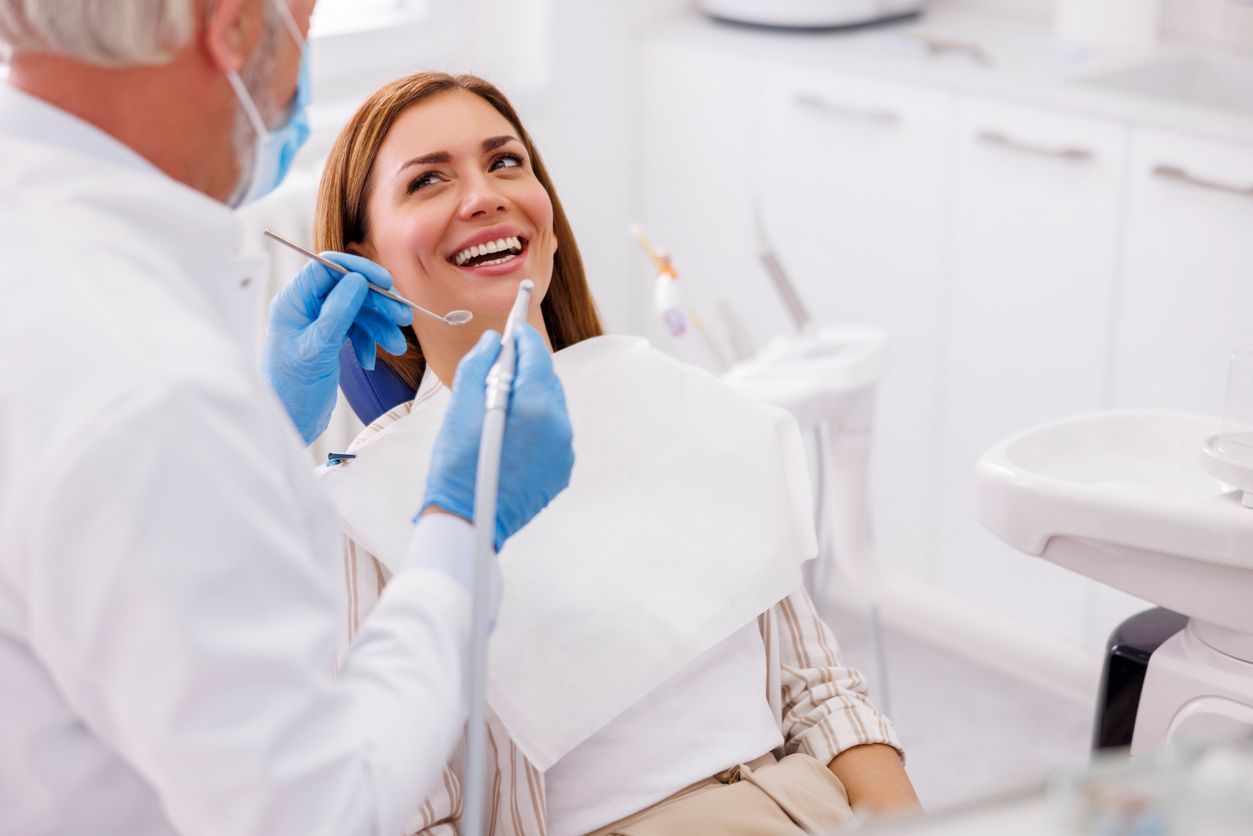 Dentist examining a smiling patient in a bright dental clinic