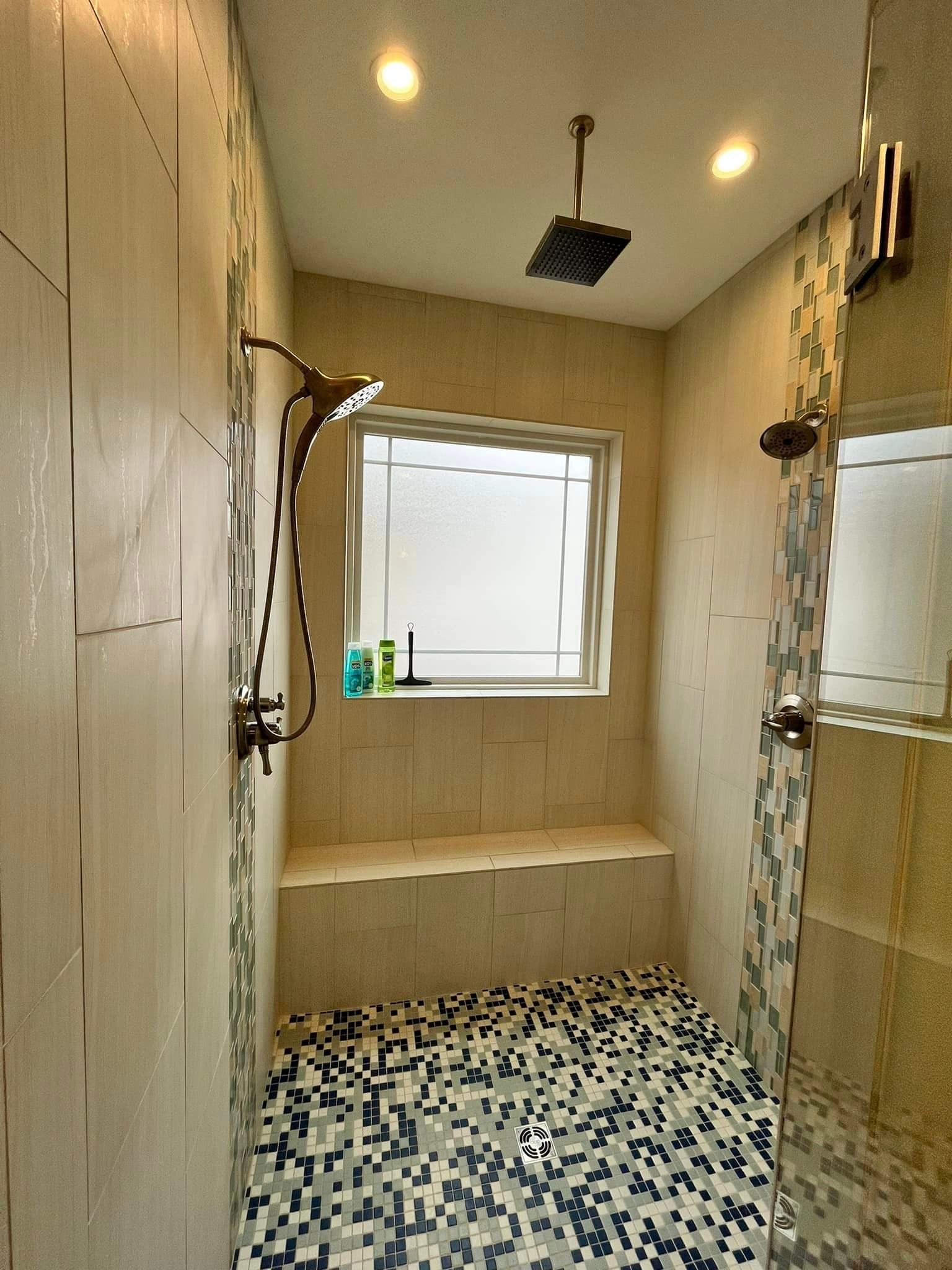 Small tiled shower room with white walls, a bench, window, and patterned floor.