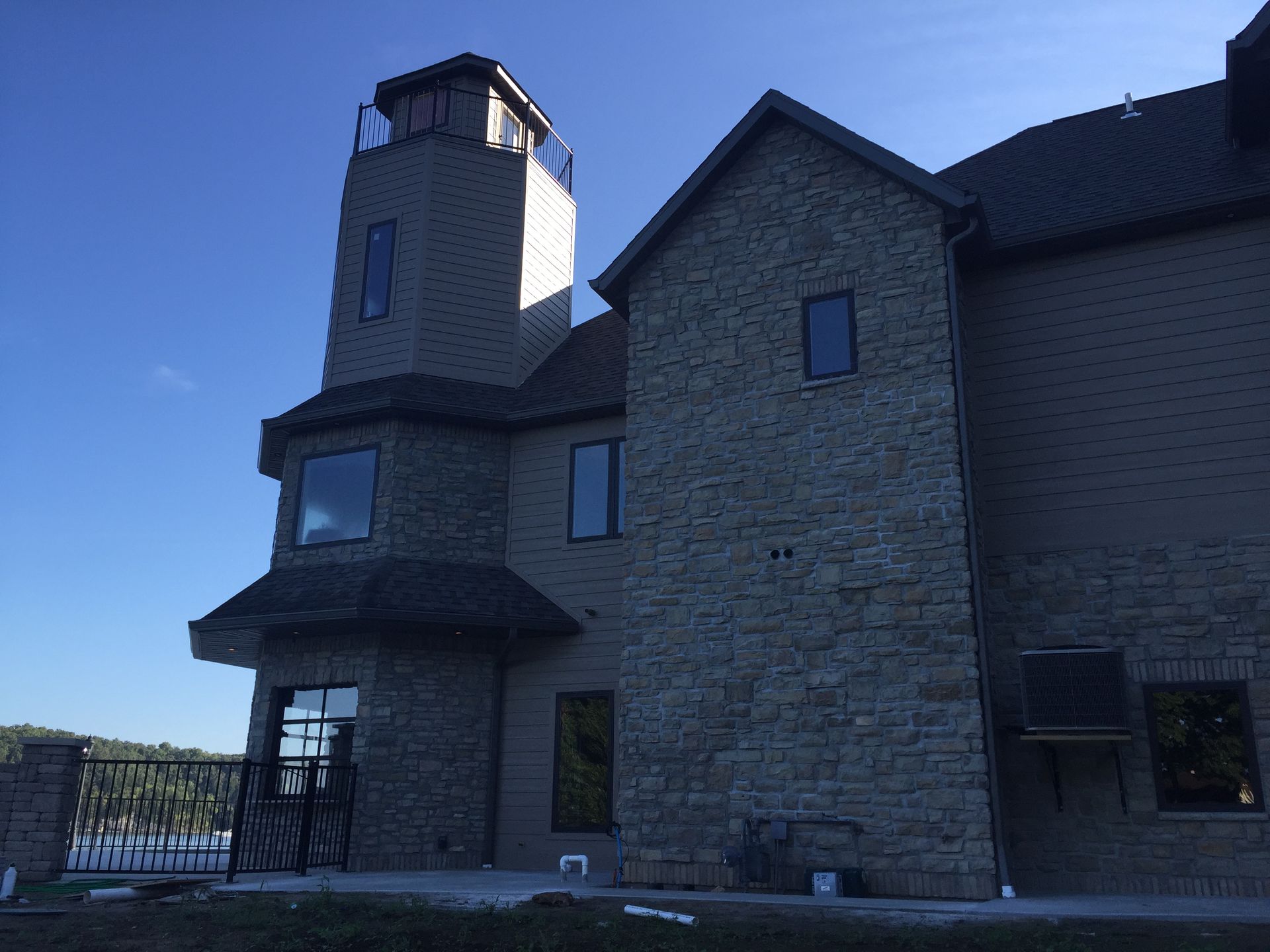 Stone building with tower and dark roof under a clear blue sky