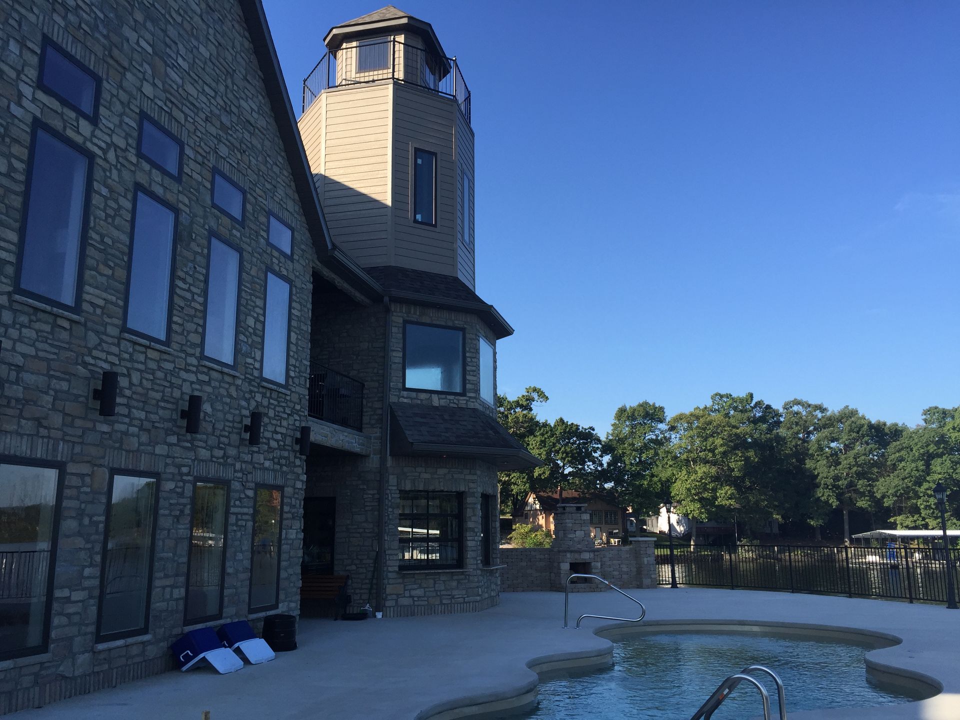 Stone building with tower beside a small pool under a clear blue sky