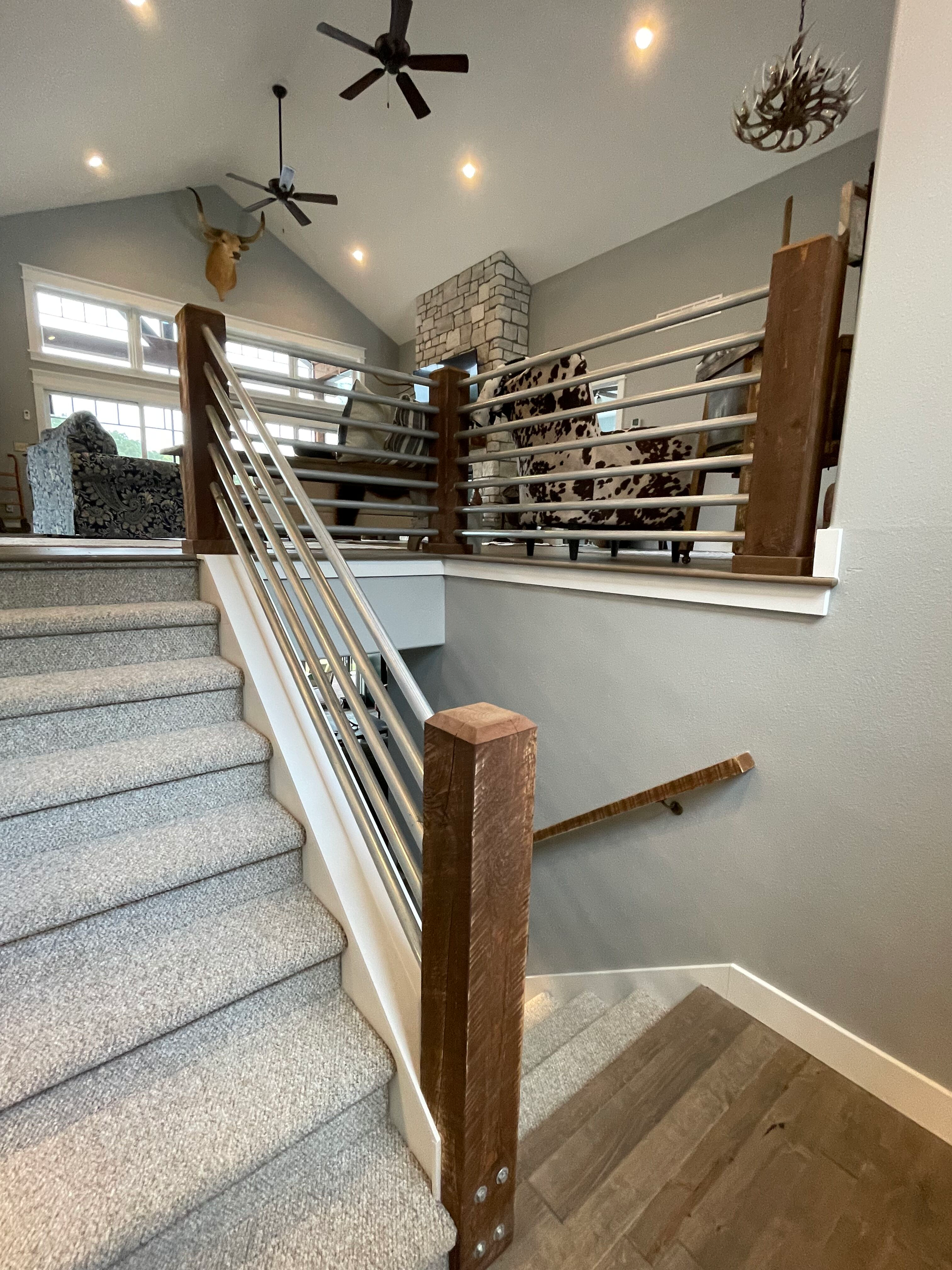 Carpeted staircase with white railings and wooden posts in a bright indoor foyer