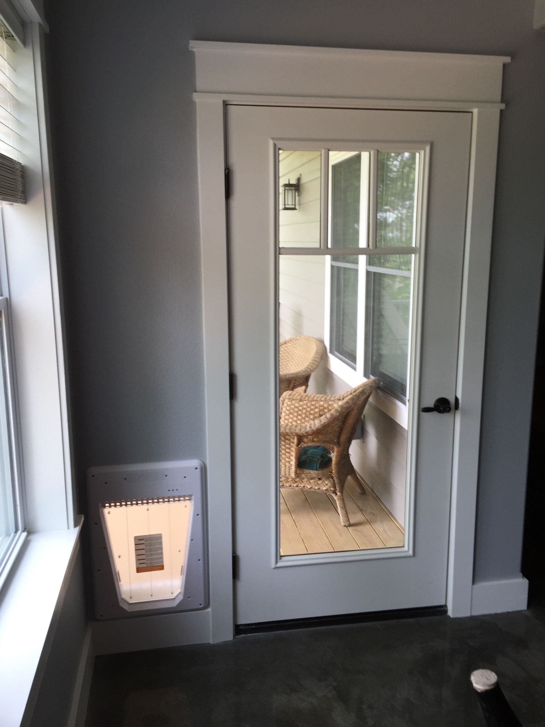 French doors with glass panes in a gray room, opening to a patio chair outside.