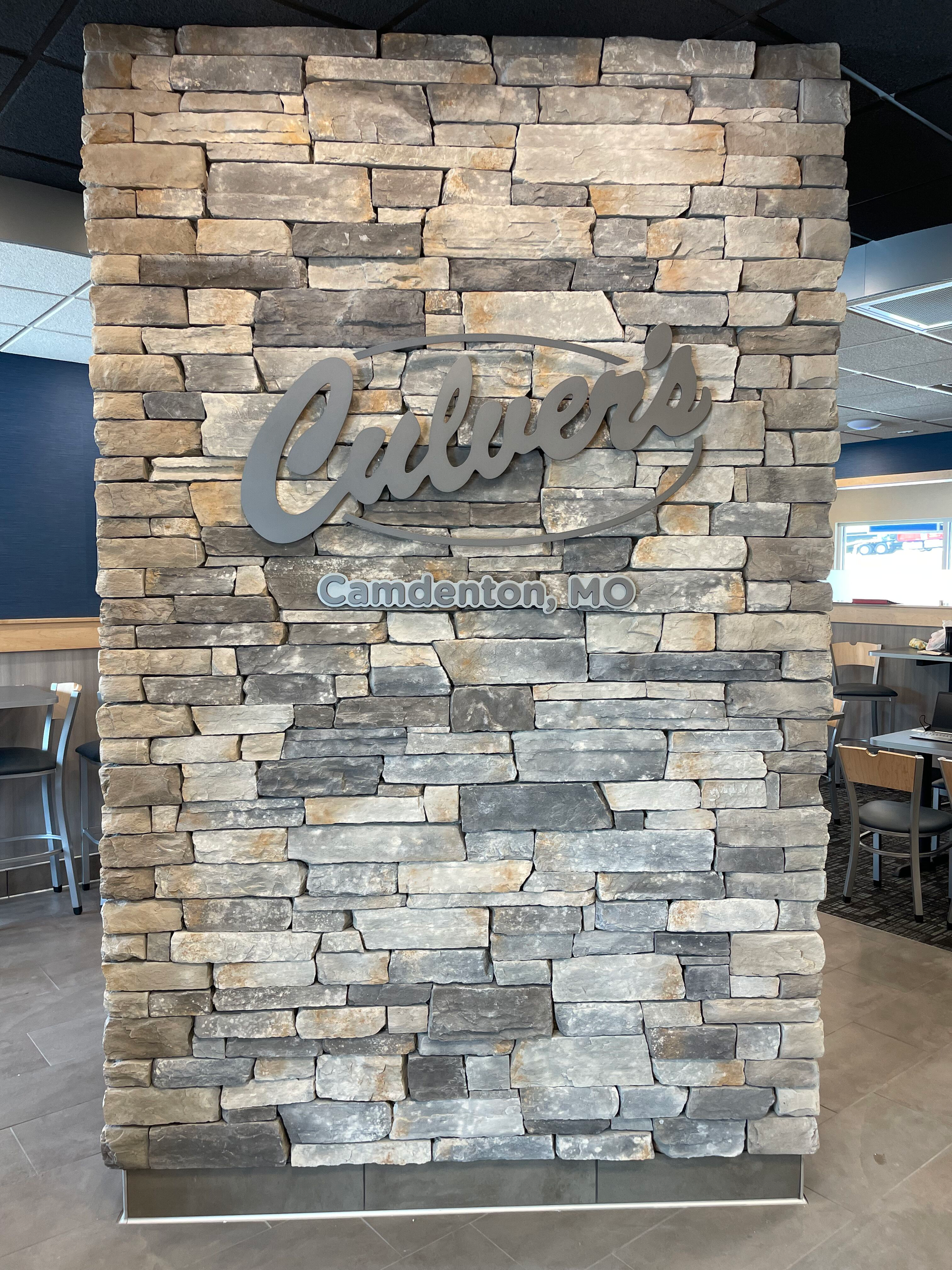 Stone wall with a metallic “Carter’s” sign in a restaurant interior