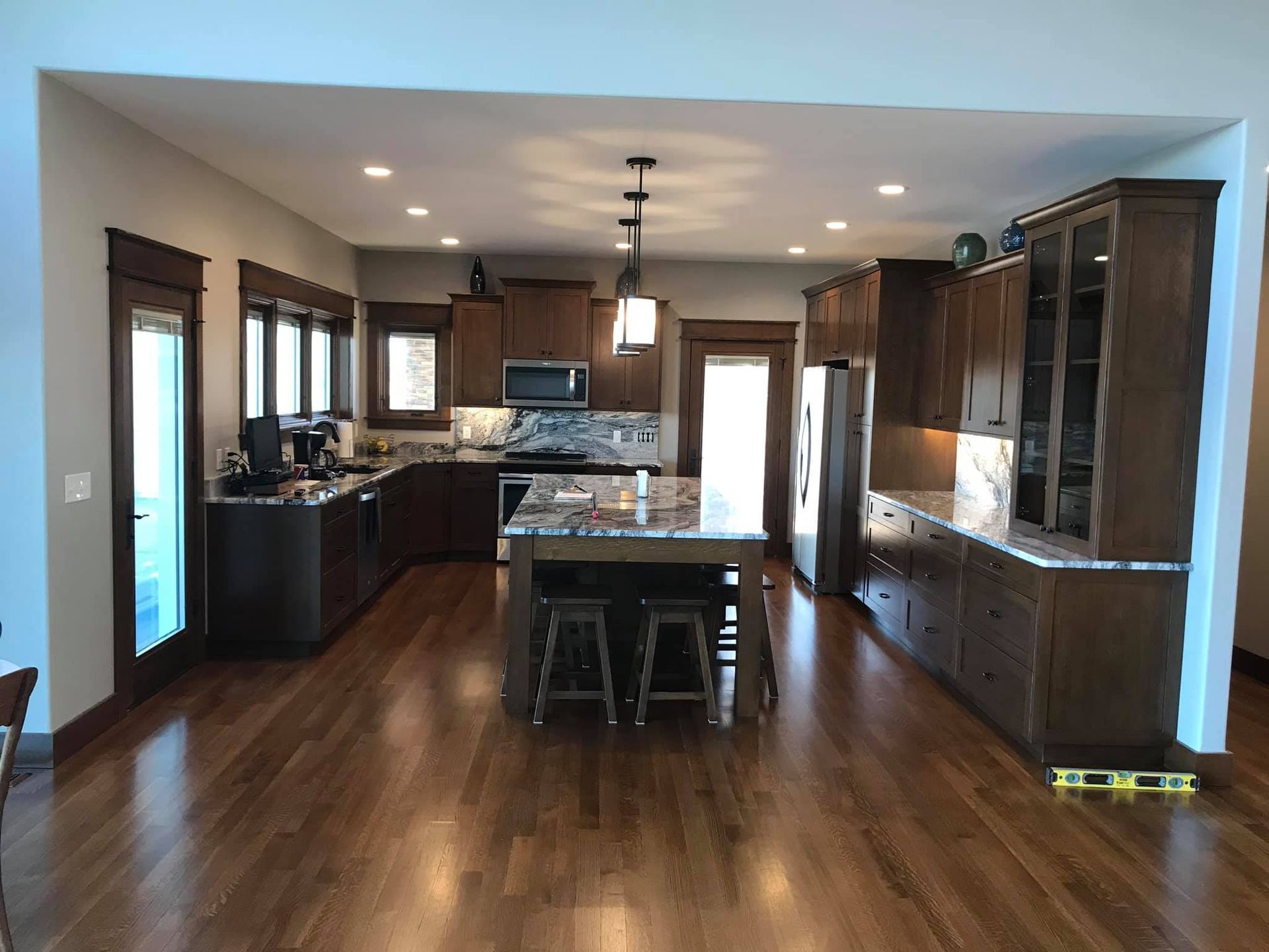 Spacious modern kitchen with dark wood cabinets, center island, and hardwood floors