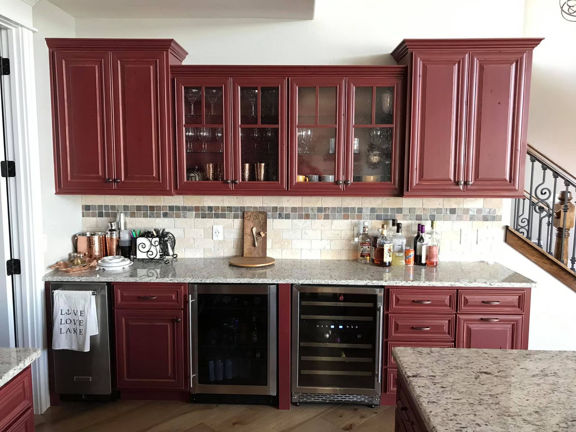 Red kitchen with dark wood cabinets, granite countertops, and stainless steel appliances