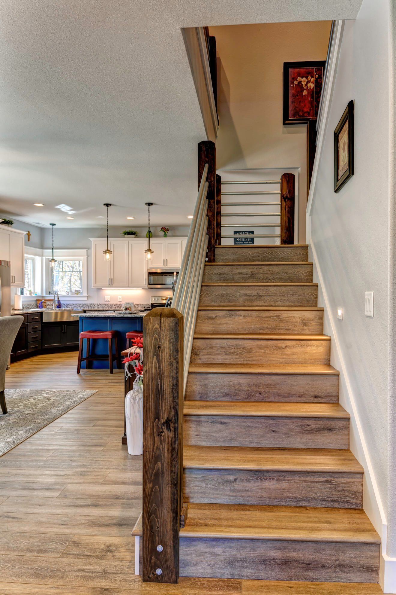 Staircase with wooden steps and railing in a bright open-concept home interior