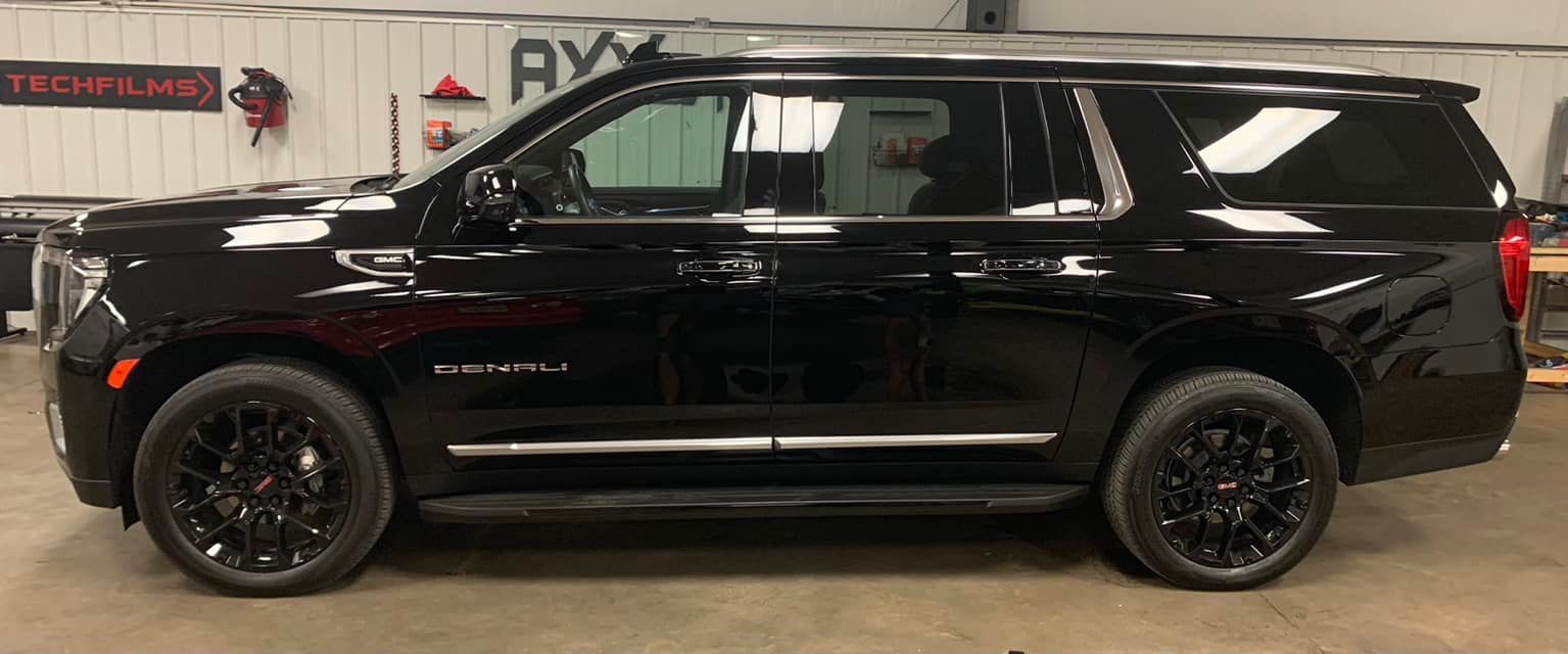 A black suv is parked in a garage.