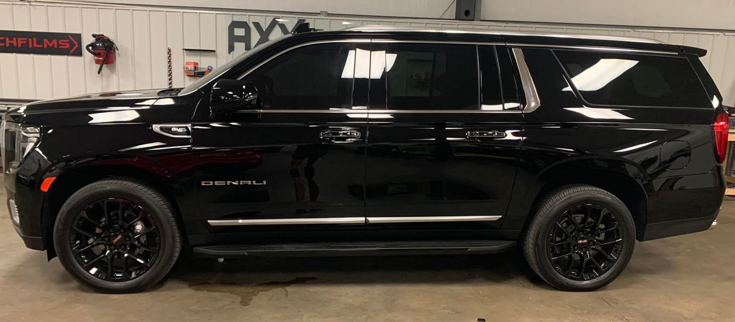 A black suv is parked in a garage.