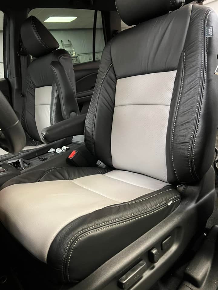 A black and white leather seat in a car.