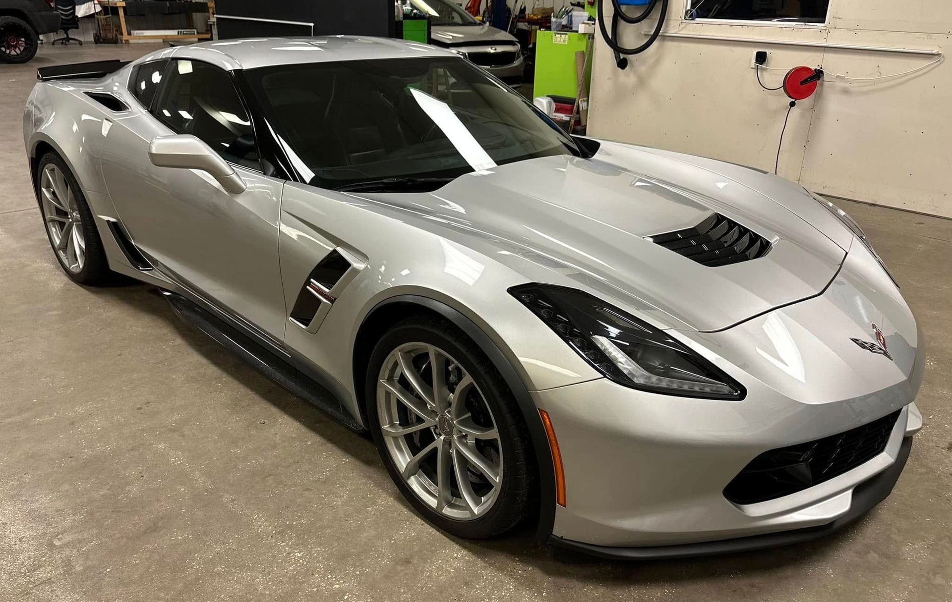 A silver sports car is parked in a garage.