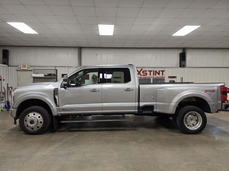 A silver pickup truck is parked in a garage.