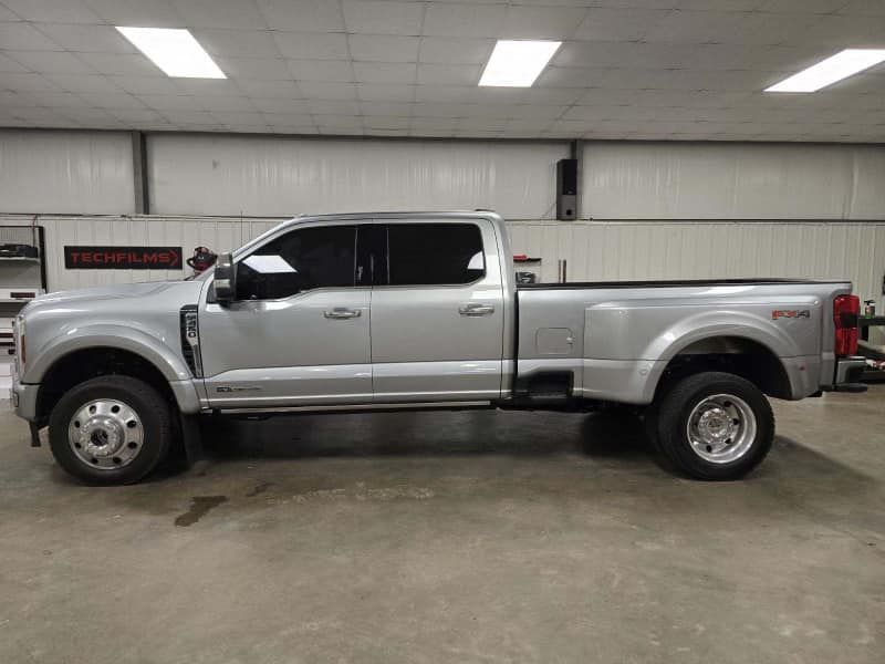 A silver pickup truck is parked in a garage.
