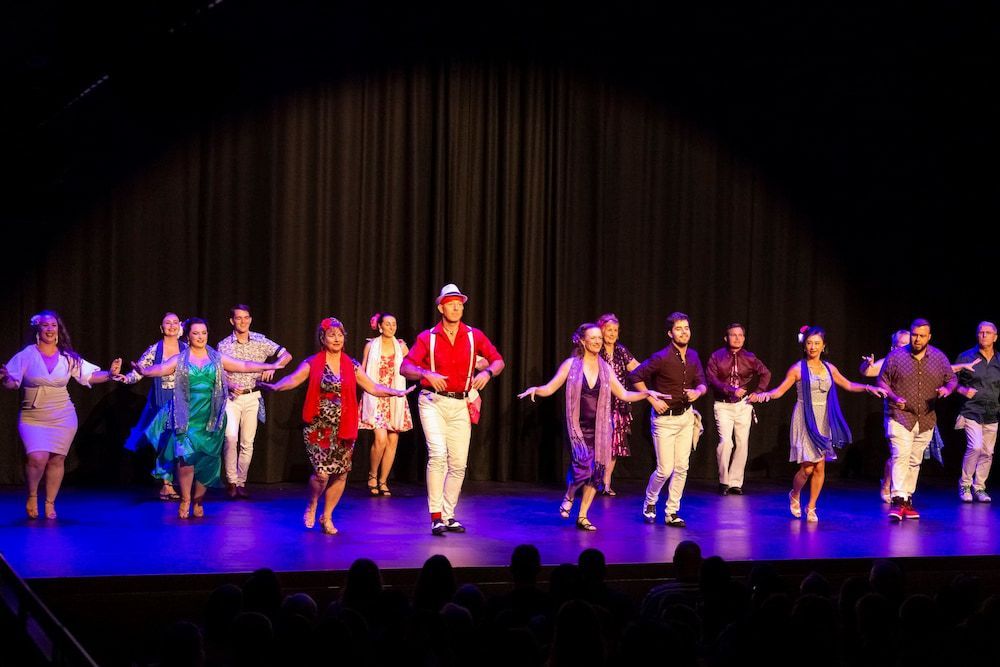 A Group Of People Are Dancing On A Stage In Front Of A Crowd — Global Dance Collective In West End, QLD