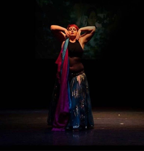 A Woman Is Dancing On A Stage In A Dark Room — Global Dance Collective In West End, QLD