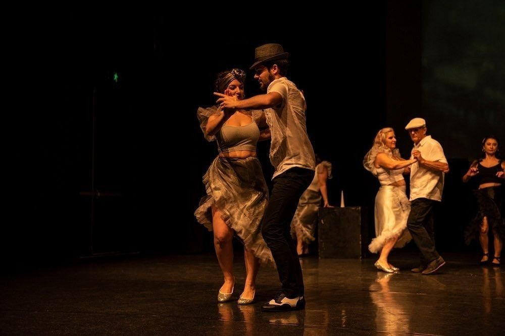 A Group Of People Are Dancing On A Stage In A Dark Room — Global Dance Collective In West End, QLD