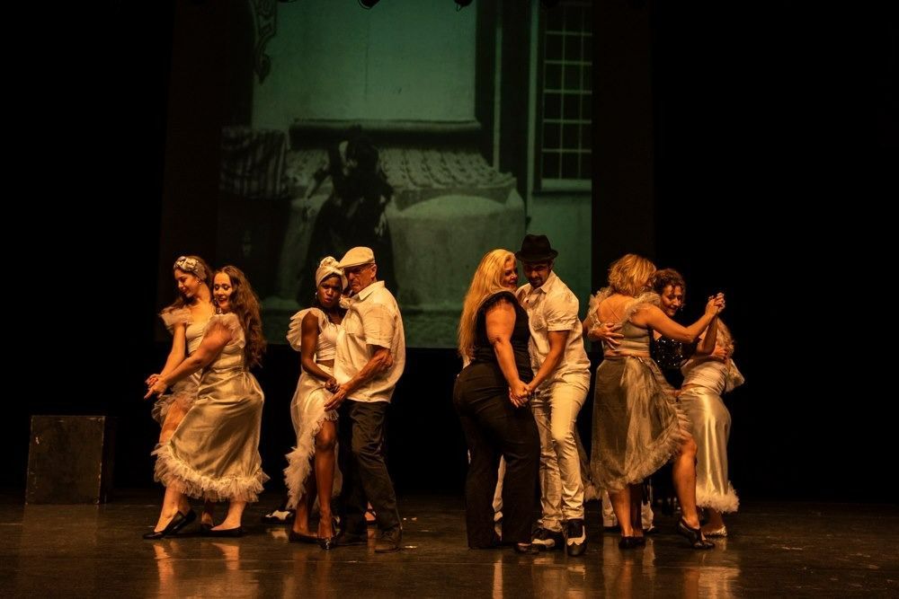 A Group Of People Are Dancing On A Stage In Front Of A Large Screen — Global Dance Collective In West End, QLD