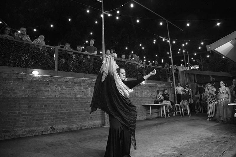 A Woman Is Dancing In Front Of A Crowd In A Black And White Photo — Global Dance Collective In West End, QLD
