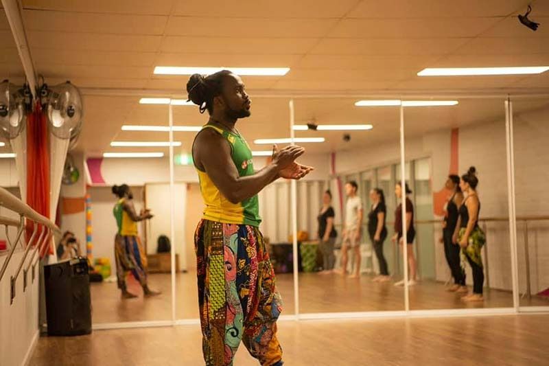 A Man Is Dancing In A Dance Studio In Front Of A Mirror — Global Dance Collective In West End, QLD