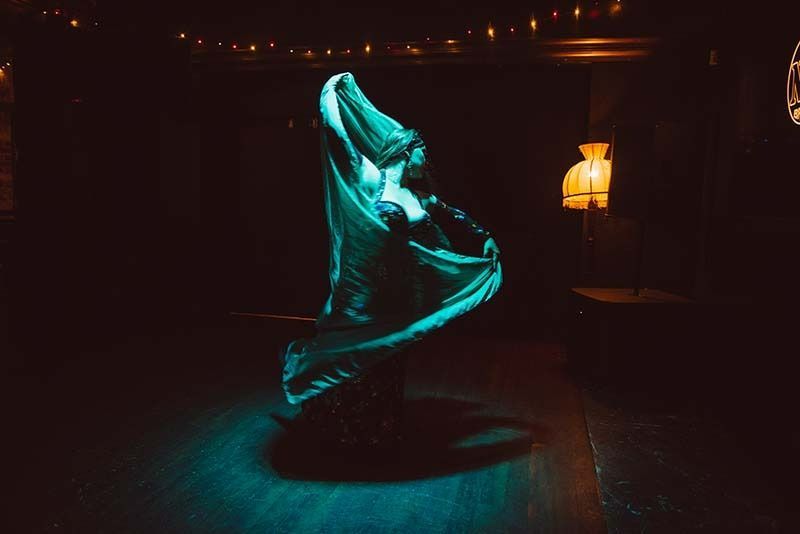 A Woman Is Dancing In A Dark Room With A Green Light Behind Her — Global Dance Collective In West End, QLD