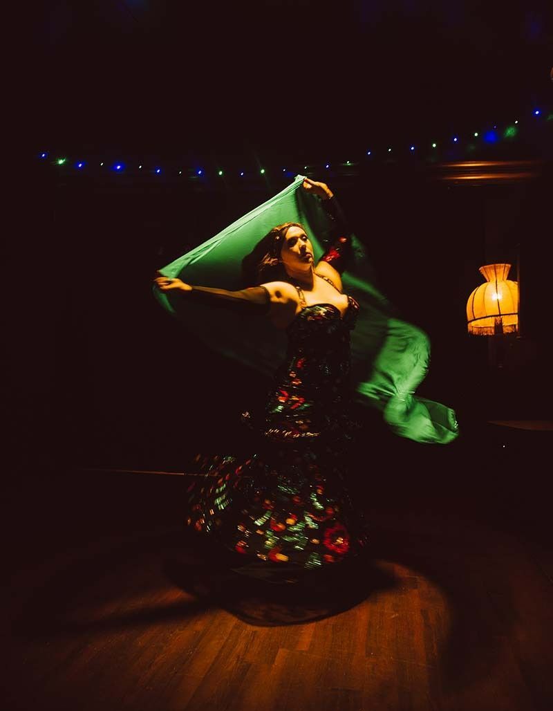 A Woman In A Green Dress Is Dancing In A Dark Room — Global Dance Collective In West End, QLD