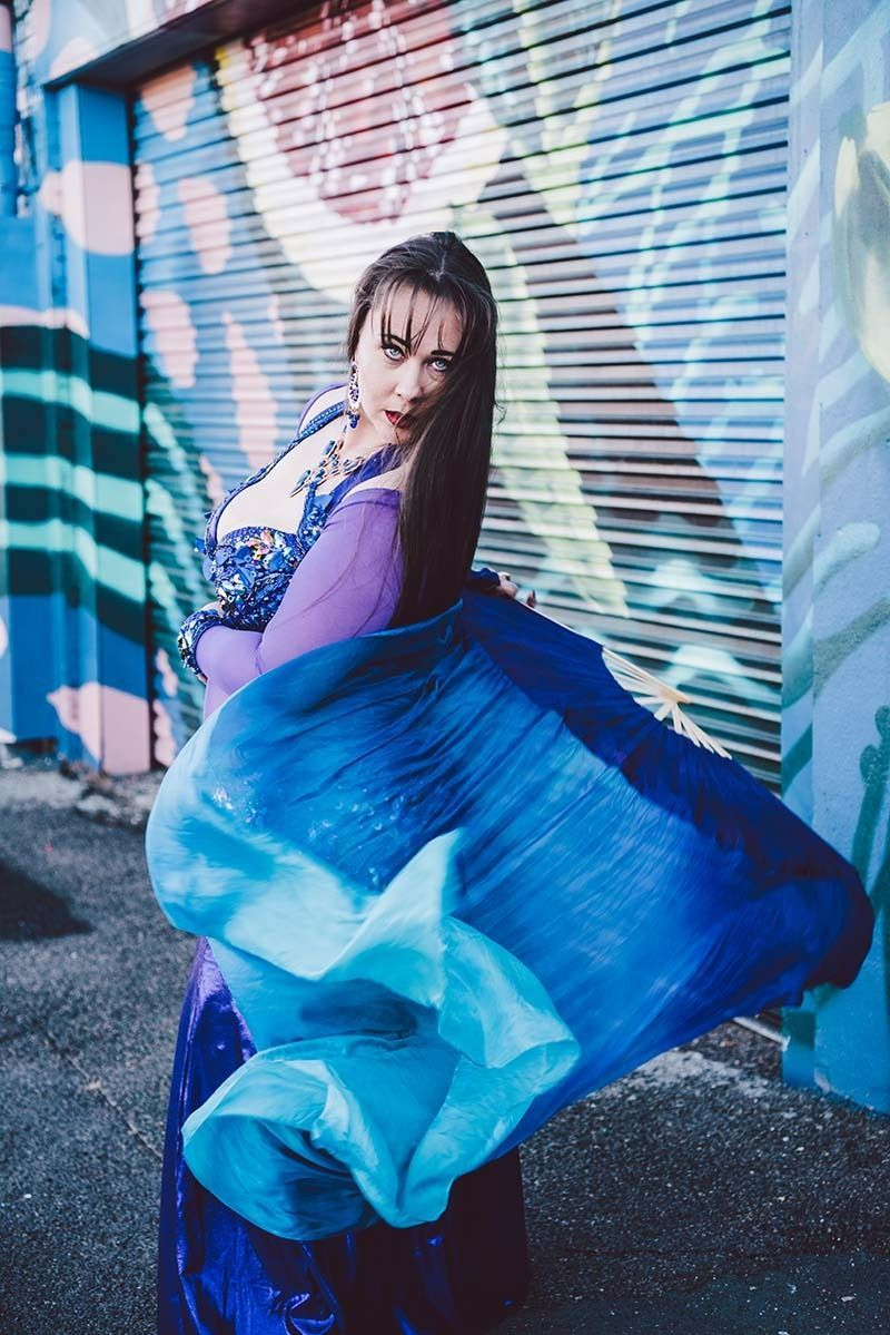 A Woman In A Blue Dress Is Dancing In Front Of A Graffiti Wall — Global Dance Collective In West End, QLD