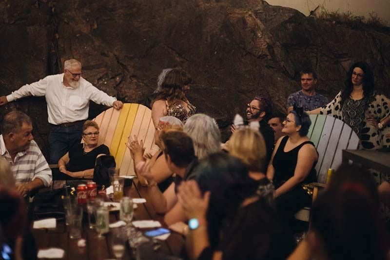 A Group Of People Are Sitting At A Table In A Dark Room — Global Dance Collective In West End, QLD