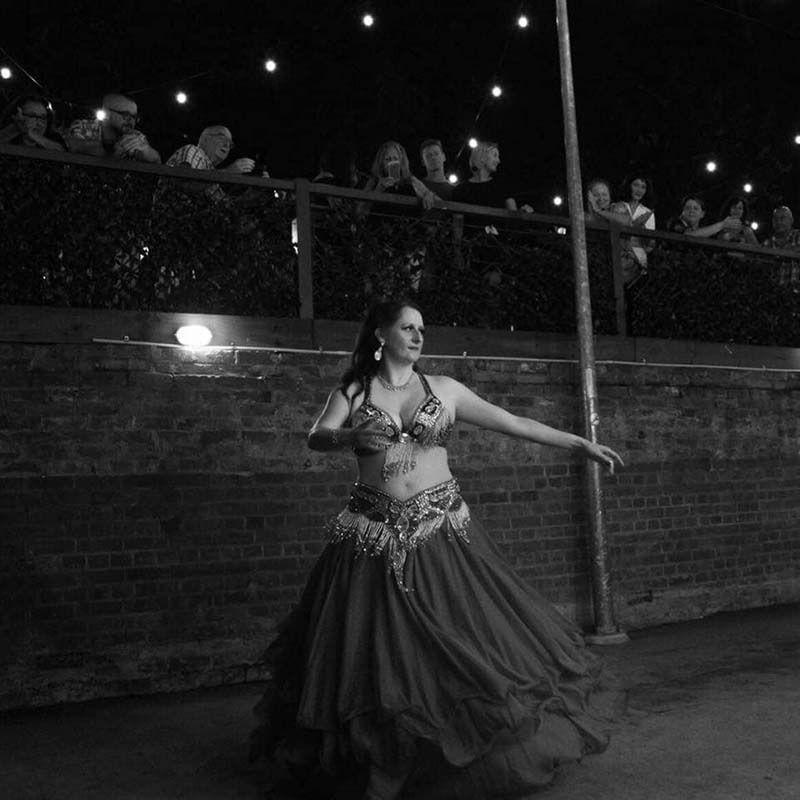 A Black And White Photo Of A Belly Dancer In Front Of A Crowd — Global Dance Collective In West End, QLD