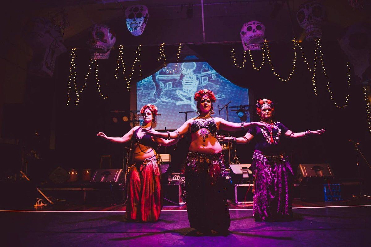 Three Belly Dancers Are Performing On A Stage In A Dark Room — Global Dance Collective In West End, QLD