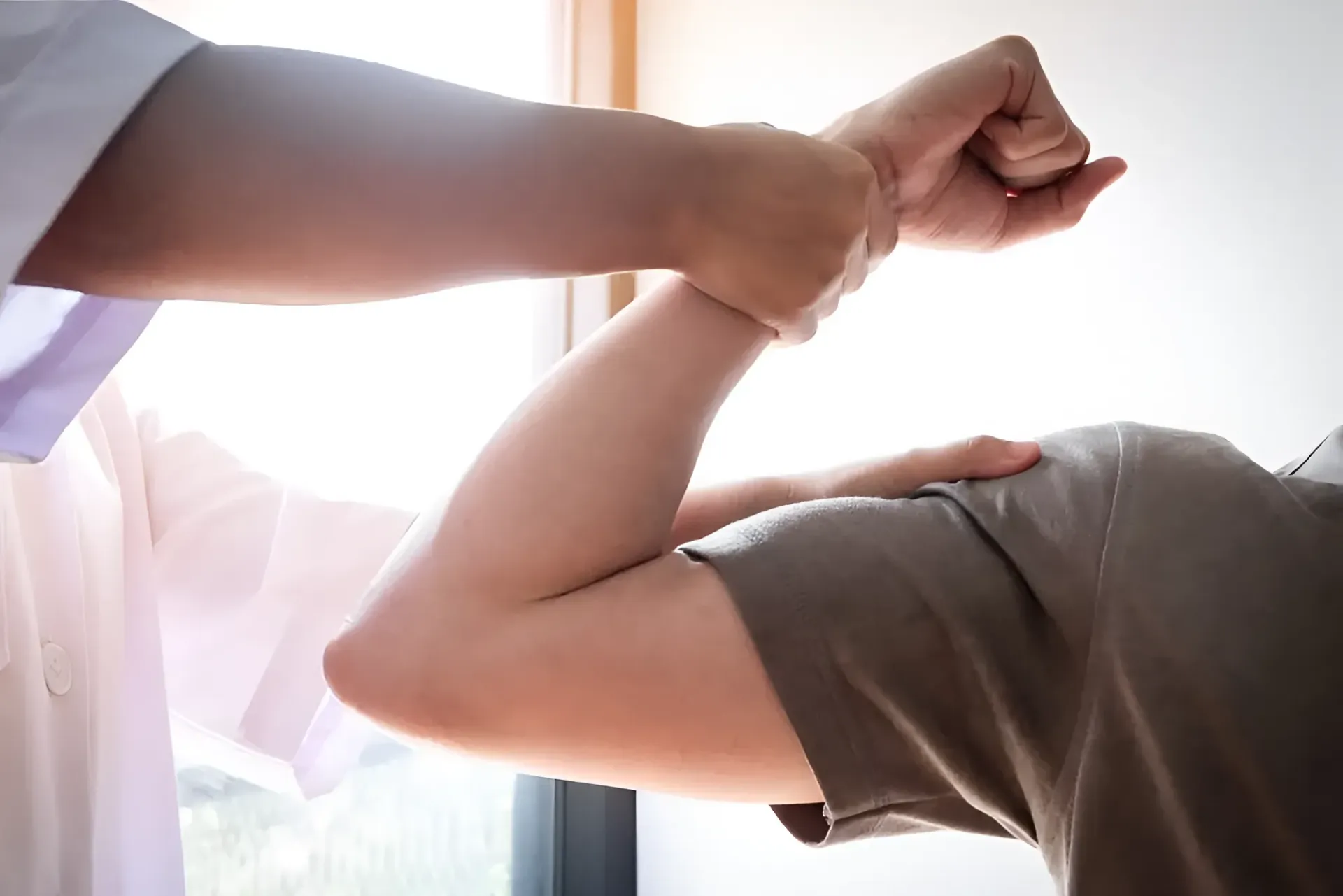 Doctor Manipulating Patient's Arm, Assessing Shoulder Mobility — Barolin Physiotherapy Services in Bundaberg South, QLD