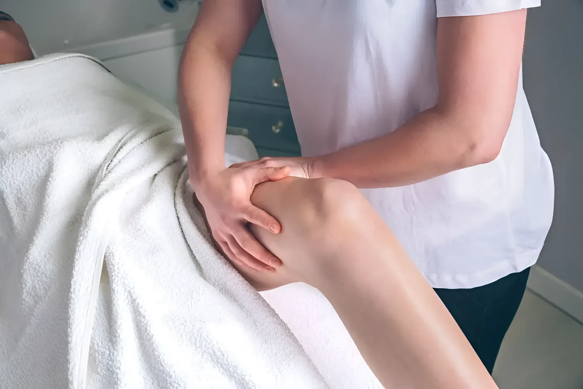 Therapist Massaging a Person's Knee on a Massage Table — Barolin Physiotherapy Services in Bundaberg South, QLD