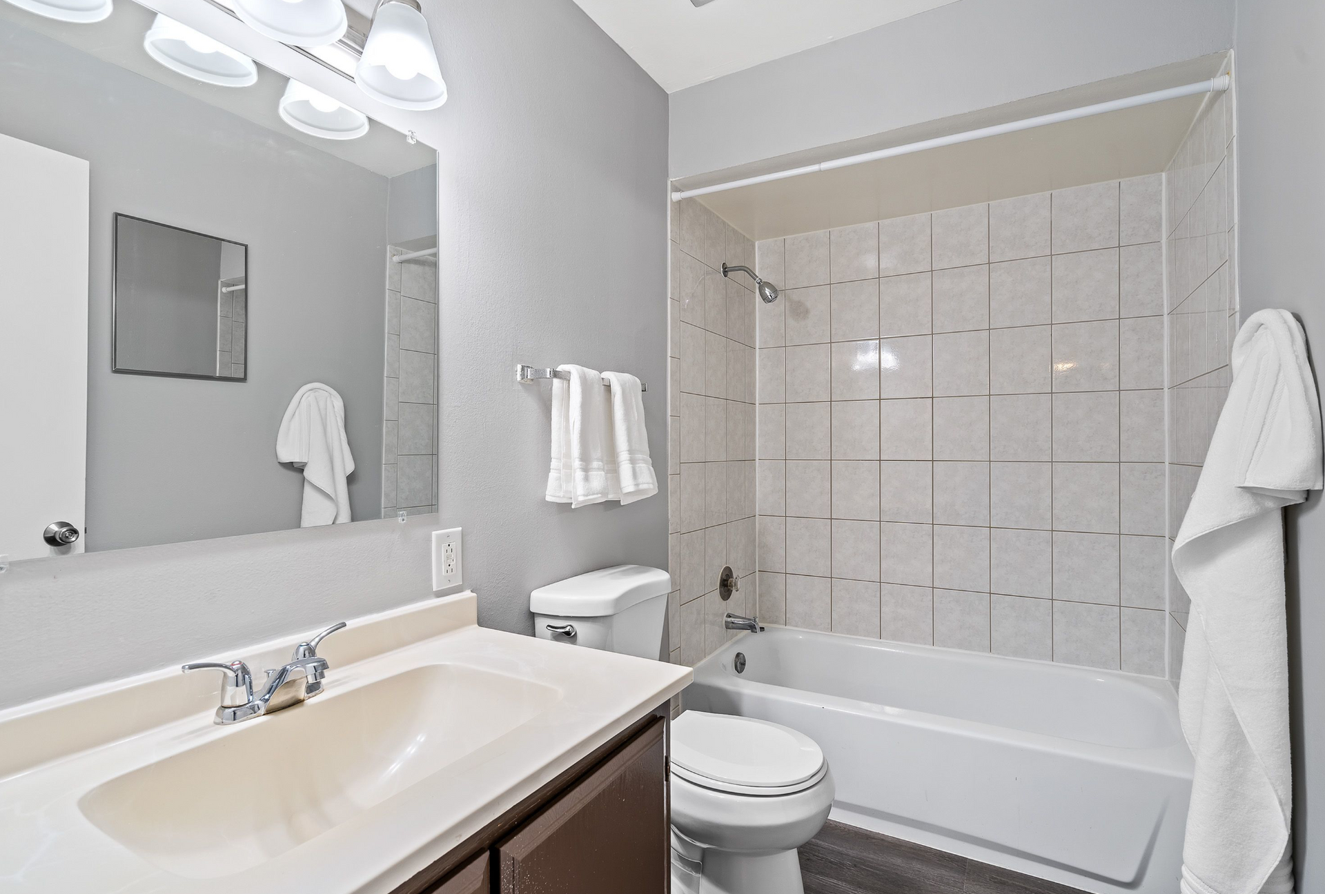 Bathroom with vanity, mirror, toilet, and tiled tub/shower.