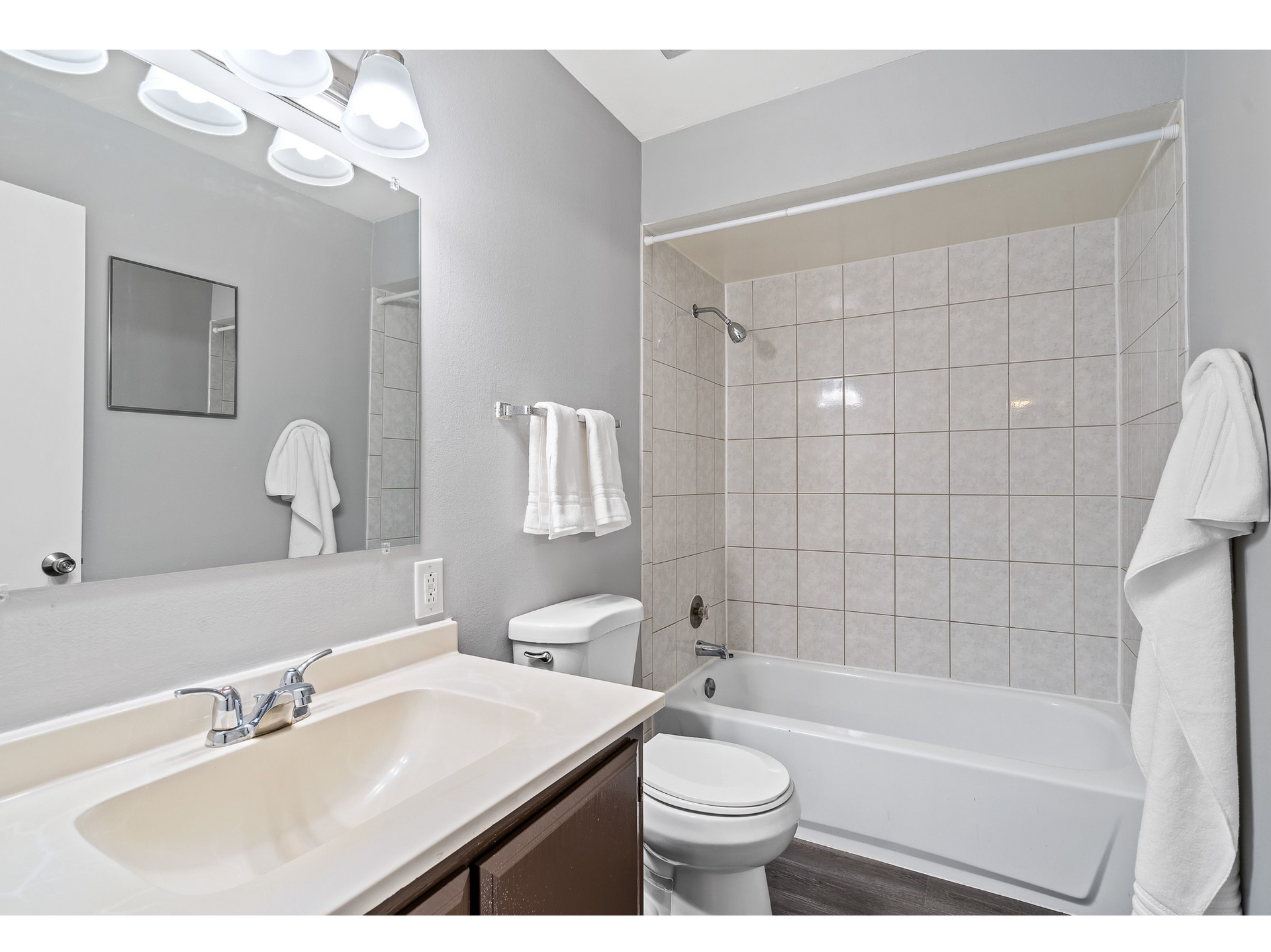 Bathroom with vanity, mirror, toilet, and tiled tub/shower.