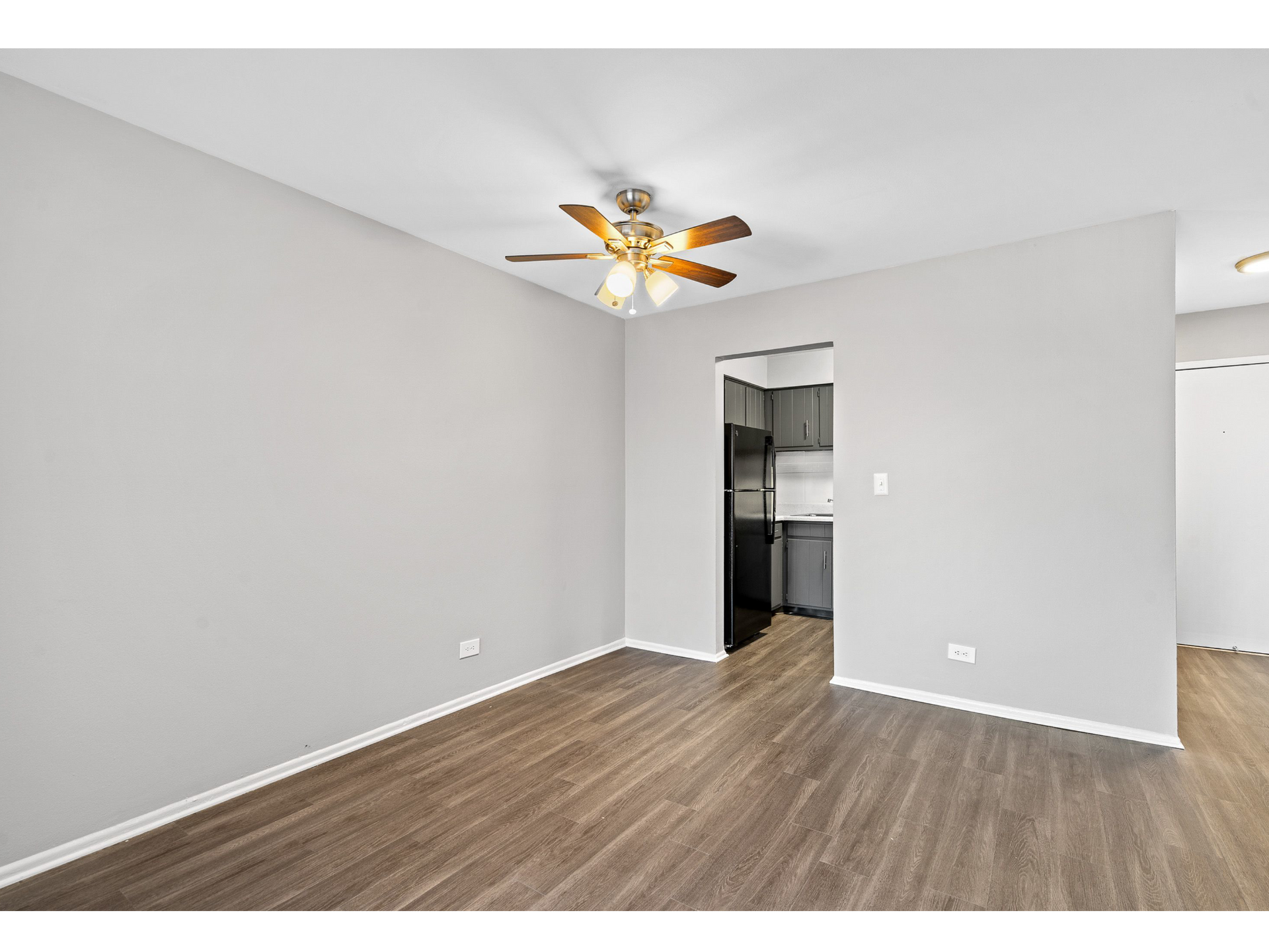 Interior living area with a ceiling fan and doorway to the kitchen.