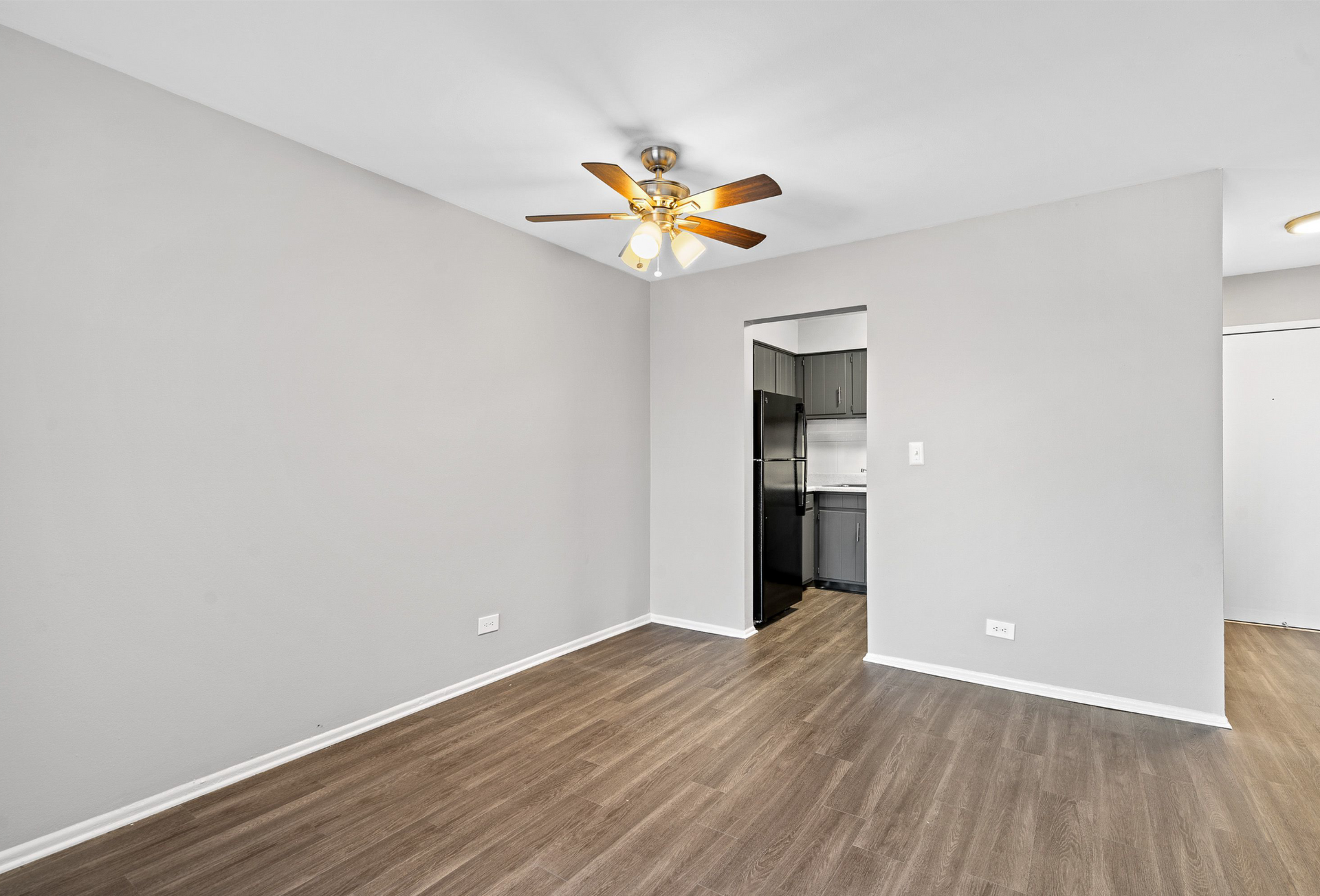 Interior living area with a ceiling fan and doorway to the kitchen.