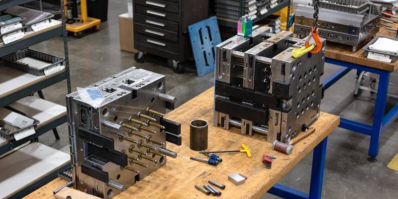 A wooden table with a lot of tools on it in a factory.