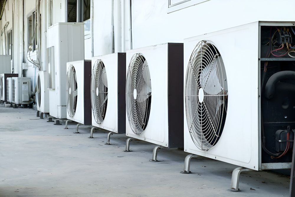 A Row Of Air Conditioners Are Lined Up On The Side Of A Building — Mason's Air Conditioning Pty Ltd in Drayton, QLD