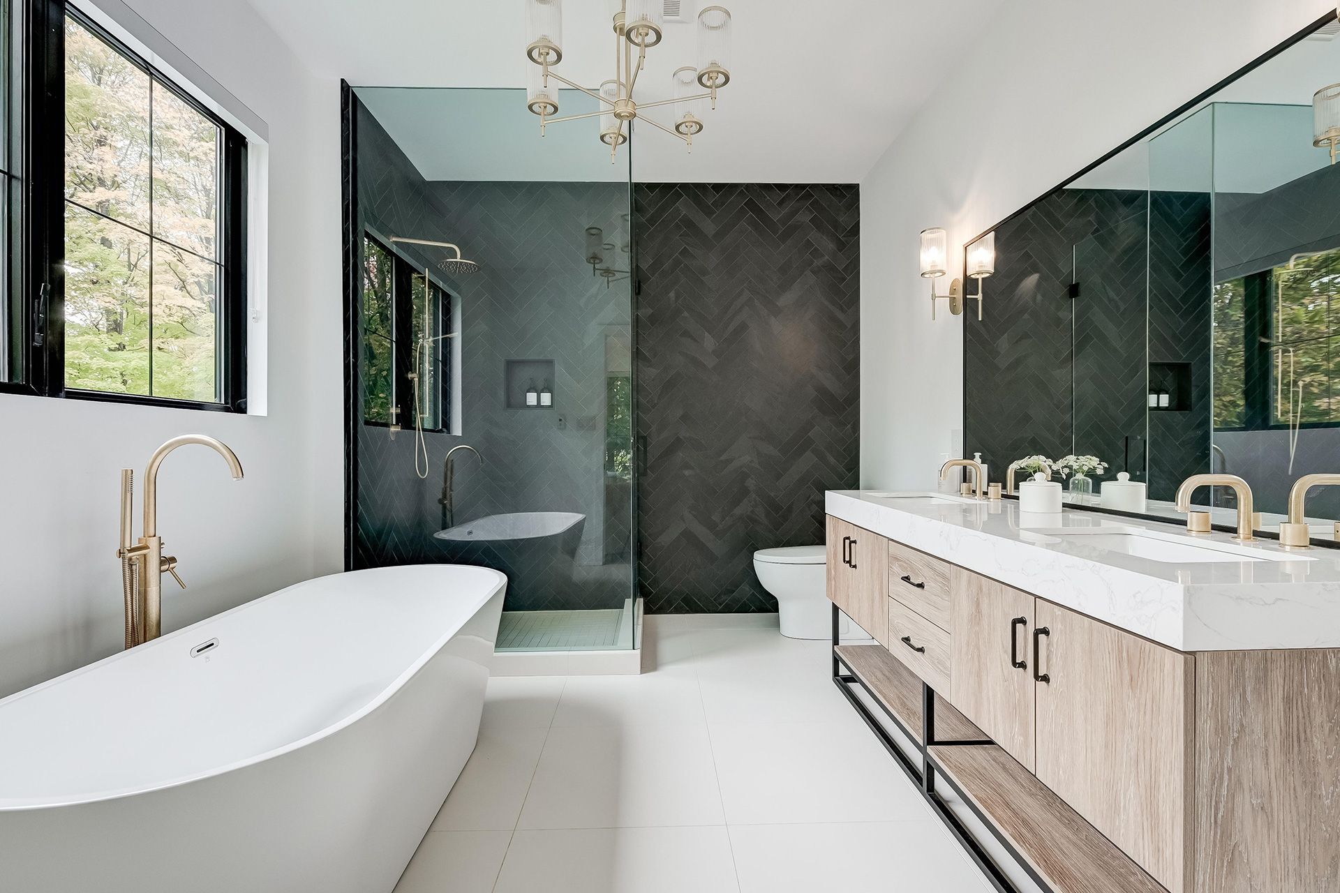 Modern bathroom with freestanding tub, double vanity, and walk-in shower in black-and-white finishes