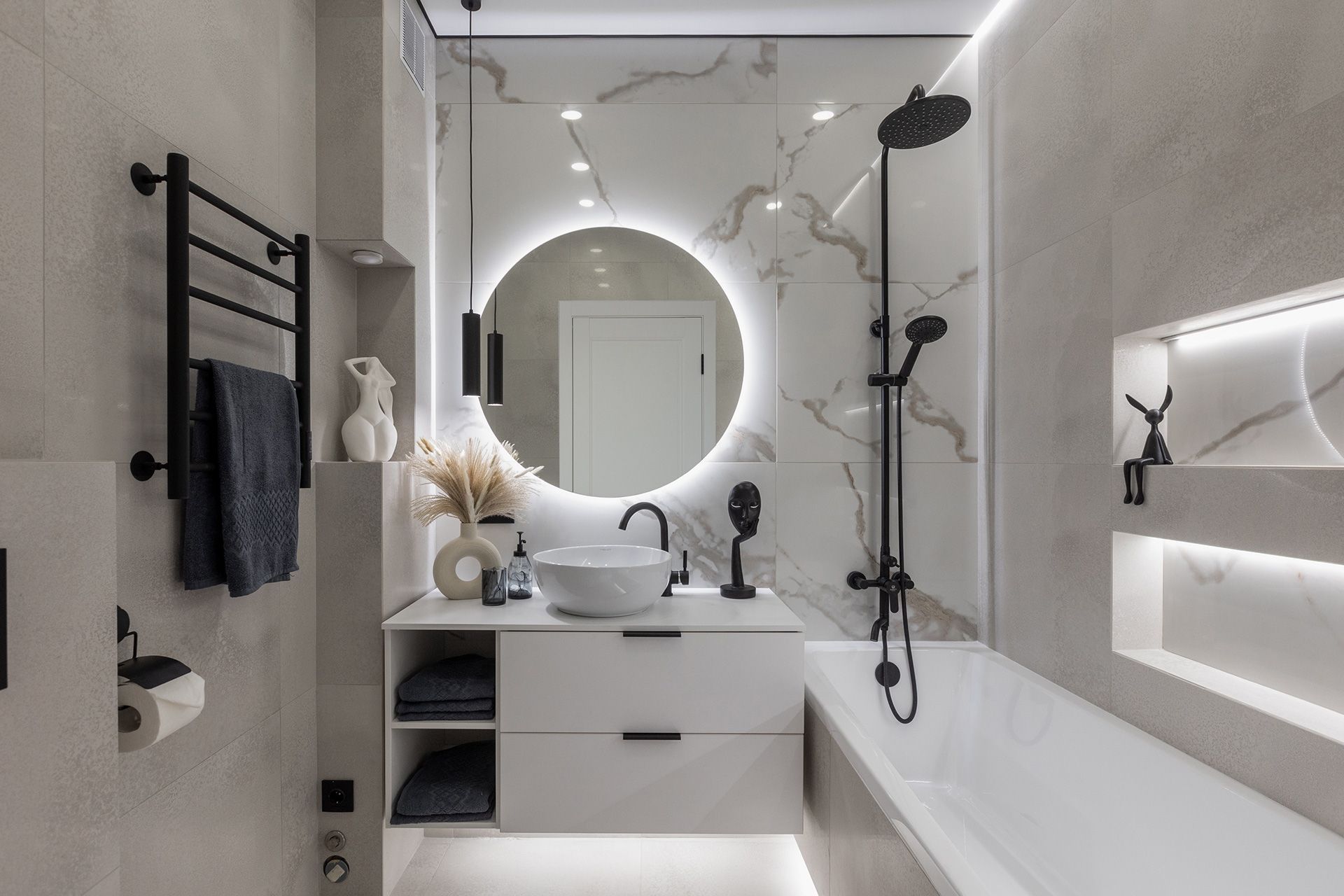 Modern white bathroom with arched mirror, double vanity, tub, and black fixtures