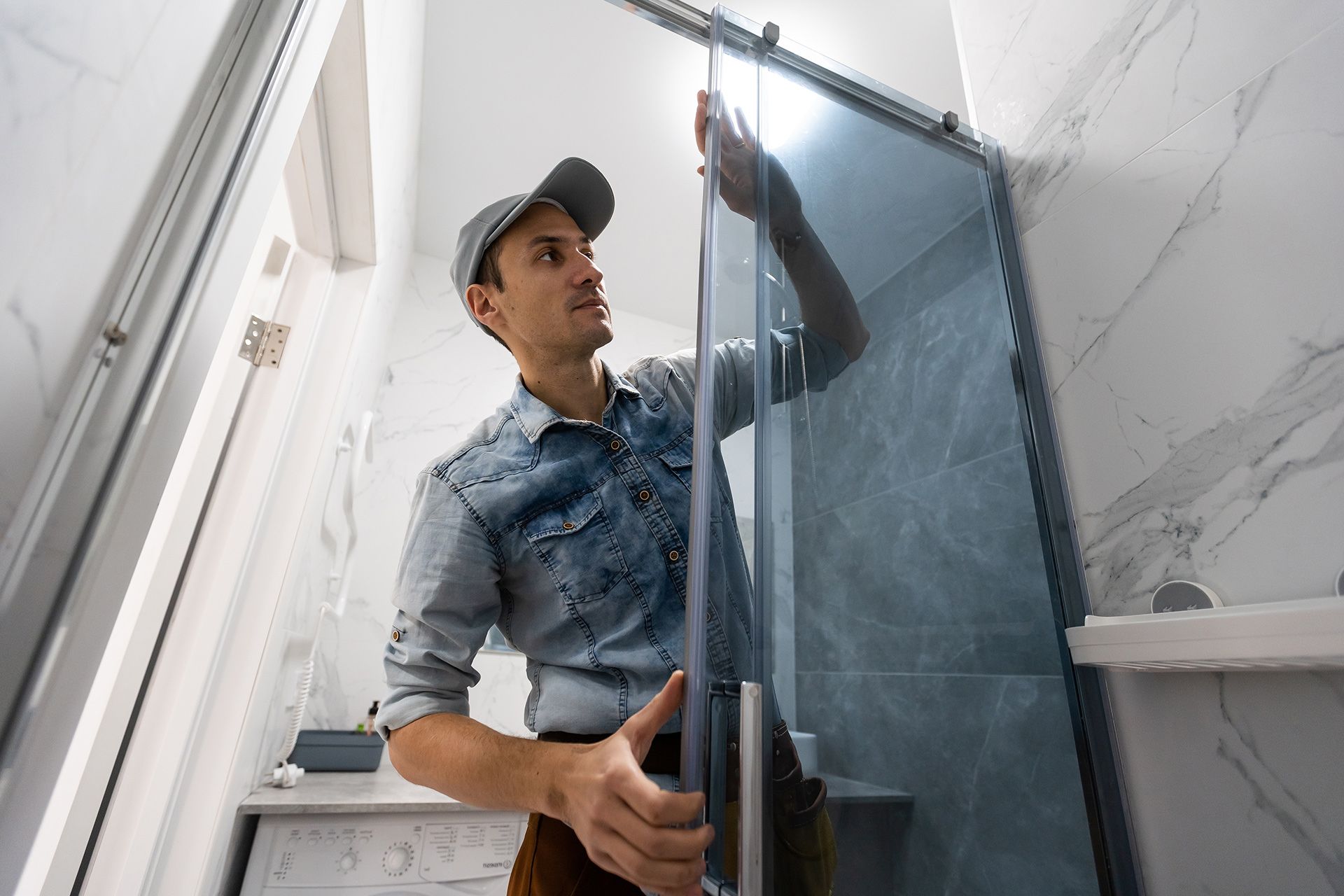 Person carrying a large glass panel up a staircase indoors