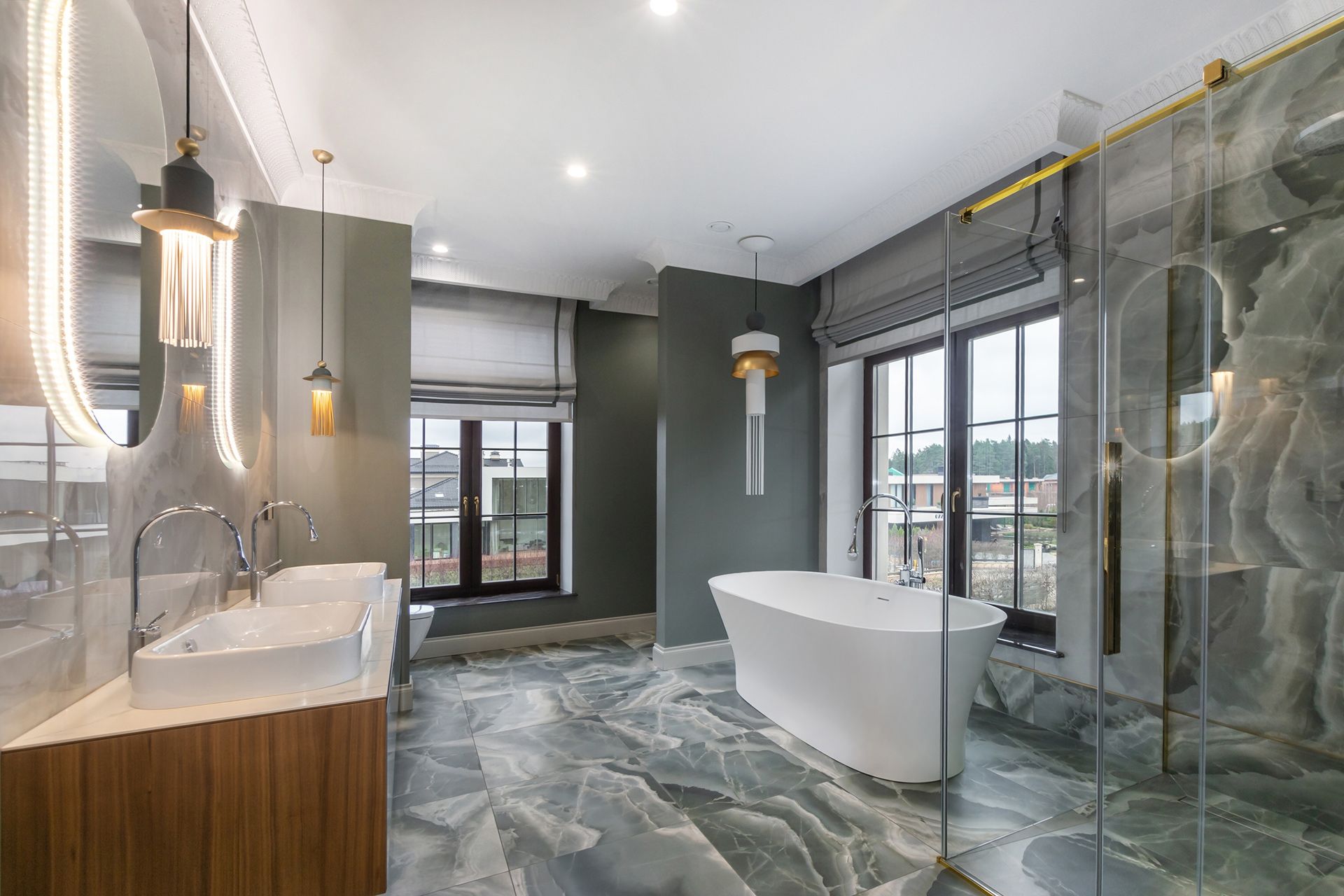 Modern bathroom with freestanding tub, glass shower, marble floor, and large windows