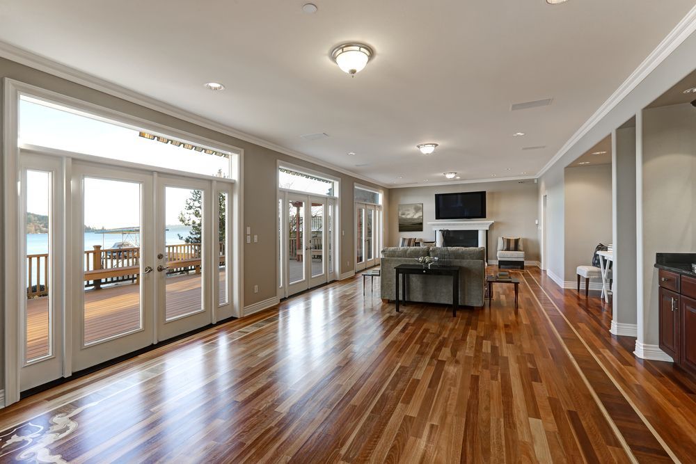 A Living Room With Hardwood Floors and Lots of Windows — Central Coast Property Maintenance Services In Gosford, NSW