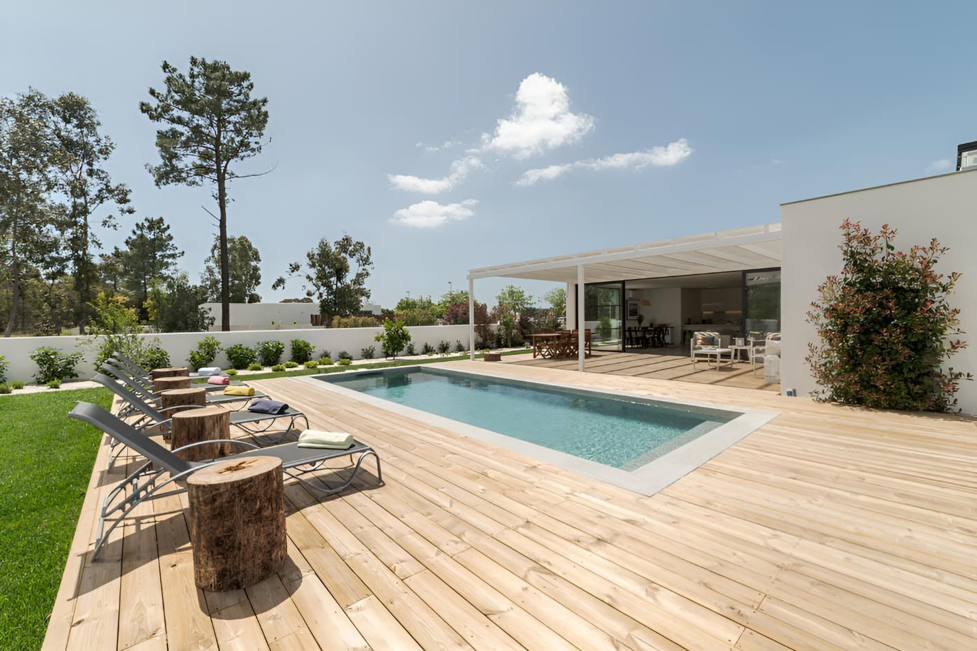 A Large Swimming Pool is Surrounded by a Wooden Deck — Central Coast Property Maintenance Services In Killcare, NSW